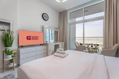 a bedroom with a bed and a tv and a table at GuestReady - Studio Suite l Community Jacuzzi in Dubai