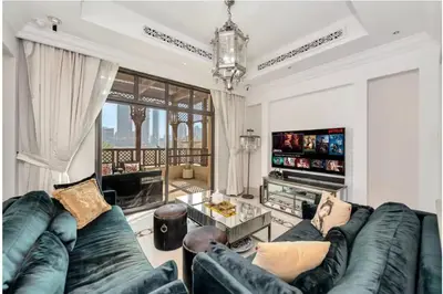 a living room with a couch and a tv at Skyline Souk 1 & 2 Bedroom Apartments I Burj Khalifa Views I Private Terrace I Gym, Pool, Parking & Wi-Fi in Dubai
