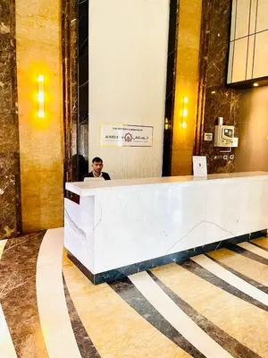 a man sitting at a reception desk in a lobby at Modern Studio With Scenic Views in Dubai