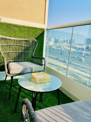 a chair and a table with a book on it on a balcony at Modern Studio With Scenic Views in Dubai