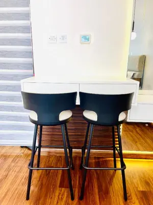 two bar stools sitting at a kitchen counter at Modern Studio With Scenic Views in Dubai