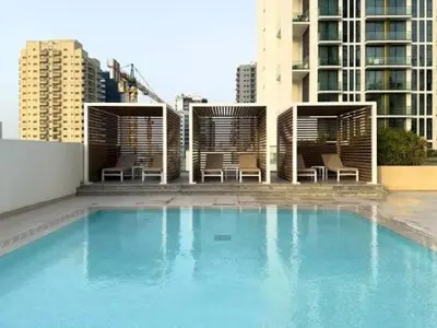 a large swimming pool with chairs and a building at LAREDA BY VIBY Vacation Homes Rental in Dubai