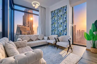 a living room with white furniture and a large window at Luxurious Apartment in Downtown near Burj Khalifa in Dubai