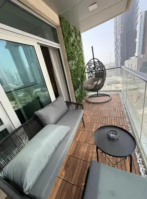 a living room with a couch and a table on a balcony at Luxurious Apartment in Downtown near Burj Khalifa in Dubai