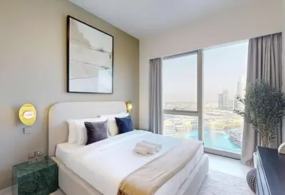 a bedroom with a large bed and a large window at Luxurious Apartment with Burj Khalifa View in Downtown in Dubai