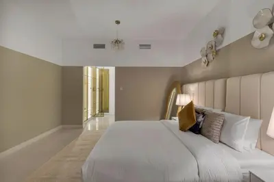 a bedroom with a large white bed with a large headboard at Luxe 2 Bedroom Apartment in Dubai Marina in Dubai