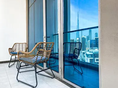 two chairs on a balcony with a view of the city at Elegant 1BDR Sleeps 4 in Bayz-22 in Dubai