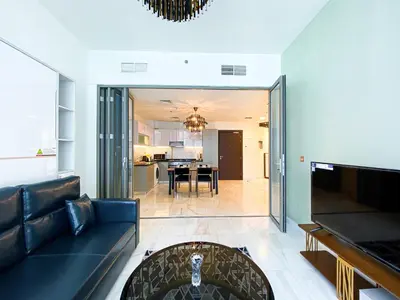 a living room with a couch and a dining room at Elegant 1BDR Sleeps 4 in Bayz-22 in Dubai