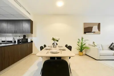 a dining room and kitchen with a table and chairs at Cozy 1BR Apartment at Elite Residence Dubai Marina in Dubai