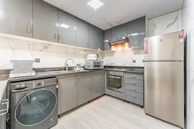a kitchen with stainless steel appliances and a washer at Compact 1BR, Just A Minute Drive to At the Top Burj Khalifa - Ontario Tower, Business Bay in Dubai
