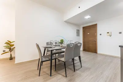 a dining room with a table and chairs at Compact 1BR, Just A Minute Drive to At the Top Burj Khalifa - Ontario Tower, Business Bay in Dubai