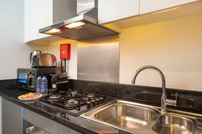 a kitchen with a sink and a stove at PVH - Damac Maison Prive - Studio with Canal and Pool View in Dubai