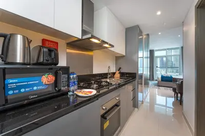 a kitchen with a counter with a microwave and a stove at PVH - Damac Maison Prive - Studio with Canal and Pool View in Dubai