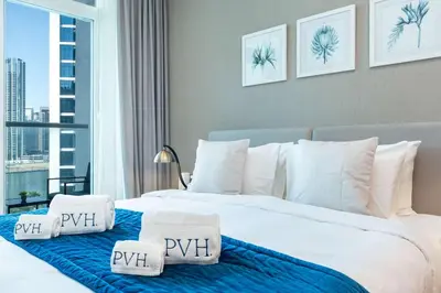 a bedroom with a large bed with pillows on it at PVH - Damac Maison Prive - Studio with Canal and Pool View in Dubai