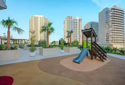 a playground on the roof of a building with palm trees at HAVN - High floor 1BR with Private Sky Pool, JVC in Dubai