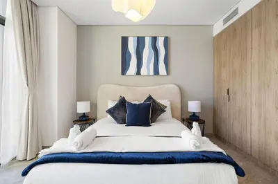 a bedroom with a large bed with blue pillows at Stylish 1BR Apartment Peninsula One Business Bay in Dubai