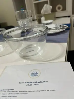 a glass bowl on a plate on a table at Chic Studio near Miracle Garden & GlobalVillage in Dubai