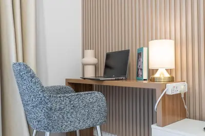 a room with a desk with a laptop and a chair at Vogue Madinat Jumeirah Living Jadeel near Burj AlArab, One-Bedroom Apartment with Large Balcony and Pool View, Access to All Amenities in Dubai