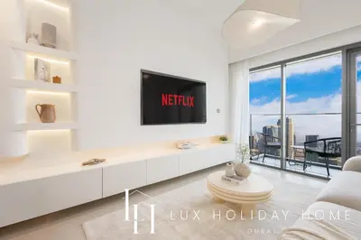 a living room with a tv and a large window at LUX 2BR High Floor - Near Dubai Mall in Dubai