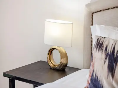 a gold ring on a table next to a bed at Livin' Holidays - 2 BR - Anantara Beach View in Dubai
