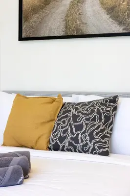 a bed with pillows and a picture on the wall at Bright Studio with Balcony Close to Downtown Dubai in Dubai