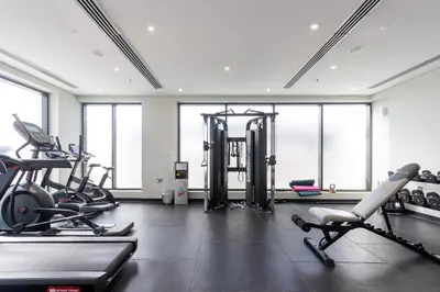 a gym with several treadmills and cardio machines at Bright Studio with Balcony Close to Downtown Dubai in Dubai
