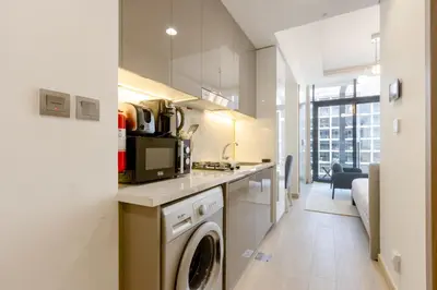 a kitchen with a washer and dryer in a room at Bright Studio with Balcony Close to Downtown Dubai in Dubai