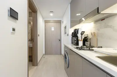 a kitchen with a sink and a washer and dryer at Bright Studio with Balcony Close to Downtown Dubai in Dubai