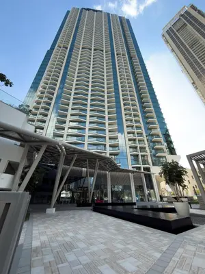 a large tall building with a plaza in front of it at Mystic - Luxe 1BR Apt with Burj Khalifa & Canal Views in Dubai
