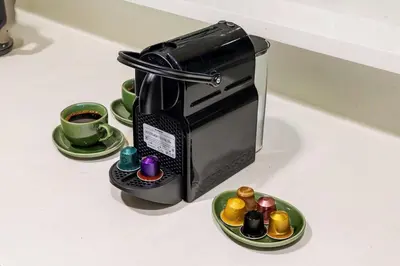 a coffee maker on a counter with plates of cupcakes at Modern 1BR Apartment in DAMAC Merano Business Bay in Dubai