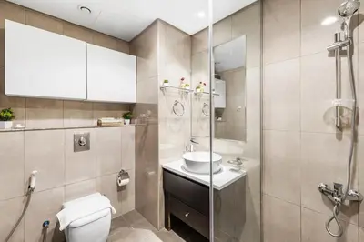 a bathroom with a toilet and a sink and a shower at Modern 1BR Apartment in DAMAC Merano Business Bay in Dubai