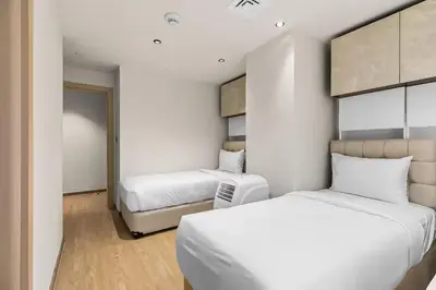 two beds in a small room with white walls at Murjan 2702 in Dubai