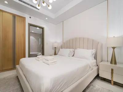 a white bedroom with a large white bed with white pillows at Luxury 1BR High floor Paramount Midtown in Dubai