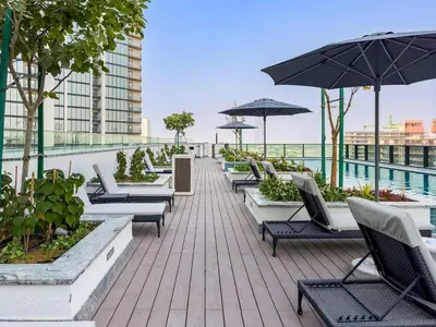 a row of chairs and umbrellas on a roof at Premium 3BR Study in Sobha Hartland in Dubai