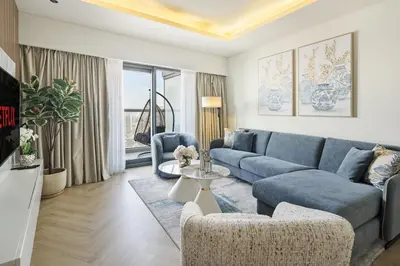 a living room with a blue couch and a table at BurjKhalifaViews,1BHK, High Floor, Damac Paramount Tower B in Dubai