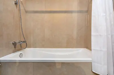 a white bath tub in a bathroom with a shower at Chic Studio in Me Do Re JLT YOLO in Dubai