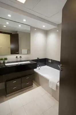 a bathroom with a tub and a large mirror at Downtown Three Beds near to Burj Khalifa and Dubai Mall in Dubai