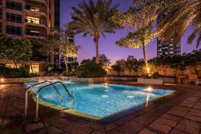 a swimming pool at night with palm trees at Downtown Three Beds near to Burj Khalifa and Dubai Mall in Dubai