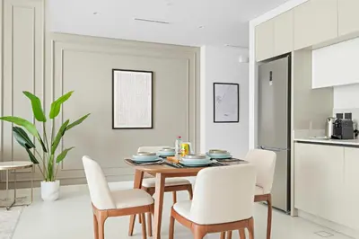 a kitchen and dining room with a table and chairs at Silkhaus 1BDR in Marina Vista Tower Private Beach in Dubai