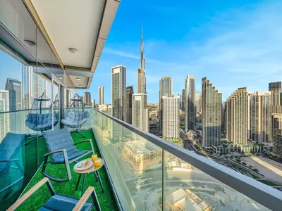a balcony with chairs and a view of the city at Restay Homes at Paramount Midtown Hotel - Infinity pool access included in Dubai