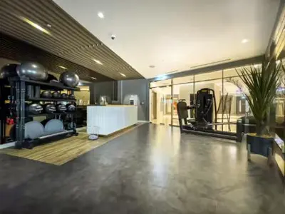 a large room with a fitness room with a gym at Restay Homes at Paramount Midtown Hotel - Infinity pool access included in Dubai