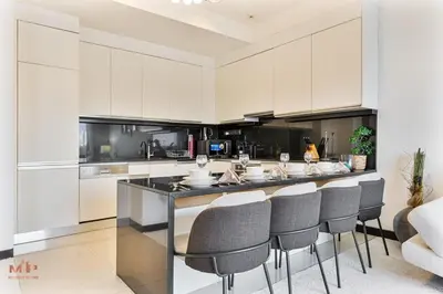 a kitchen with white cabinets and a bar with stools at Luxury 1 Bed in Marina Mall JW Marriot in Dubai