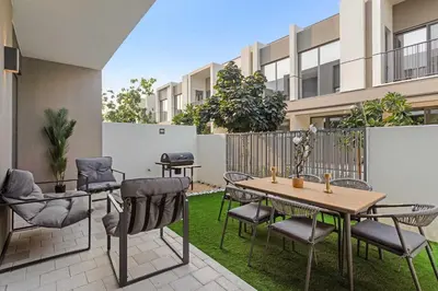 a patio with chairs and a table and a fence at Silkhaus Spacious 3BDR & Maid Tilal Al Ghaf in Dubai