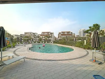 a swimming pool with people in it in a city at Silkhaus Spacious 3BDR & Maid Tilal Al Ghaf in Dubai