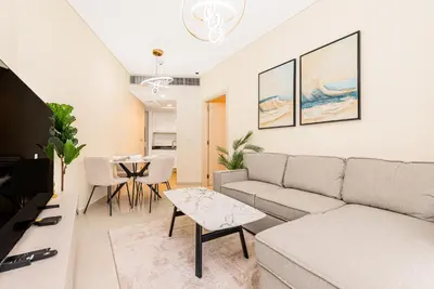 a living room with a couch and a table at Escape 24 Stylish 1BR in Artesia, Pool & Gym, Damac Hills in Dubai