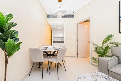 a dining room with a table and chairs at Escape 24 Stylish 1BR in Artesia, Pool & Gym, Damac Hills in Dubai