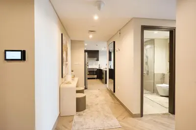 a hallway with a bathroom with a toilet and a sink at Upscale Modern 2-Bedroom with Elegant Interiors in Dubai