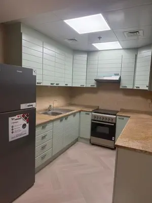 a kitchen with white cabinets and a sink and a refrigerator at 403,1 BHK lake View, V3 tower, JLT Royal Montania in Dubai
