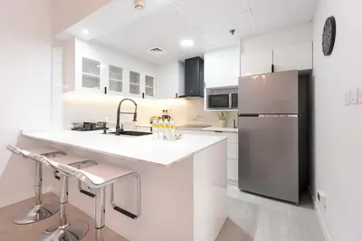 a white kitchen with a sink and a refrigerator at StayShort - Stlylish 2 Bedroom in Dubai Marina that Sleeps 4 Near Metro in Dubai