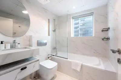 a white bathroom with a tub and a toilet and a sink at StayShort - Stlylish 2 Bedroom in Dubai Marina that Sleeps 4 Near Metro in Dubai
